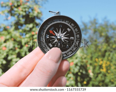 Man explorer searching direction with compass. Compass in the hand,tourism and exploration. Macro photo. Adventure, travel, stories background.  Travel geography navigation concept.Hiking Adventure.
