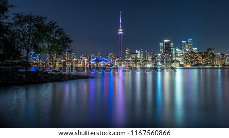 Long exposure of Toronto, Ontario - Canada. Bright sky with a smooth water surface. Beautiful city lights seen from the Toronto Island.