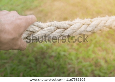 Hand is pulling a big rope for fighting concept and other