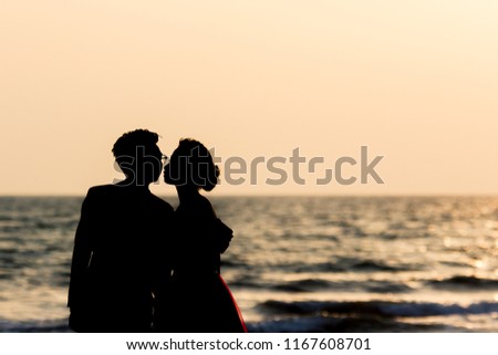 silhouette lovely couple kissing in beach during sunset