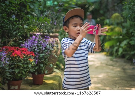 Boy taking picture using cellphone at the park