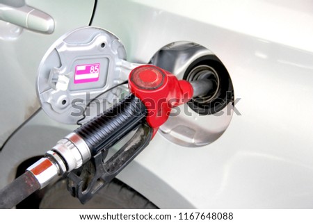 gasoline dispenser at petrol filling station.Fuel nozzle during refueling at a gas station.Fuel oil gasoline dispenser at petrol filling station.Holding fuel nozzle to refuel gasoline for car.
