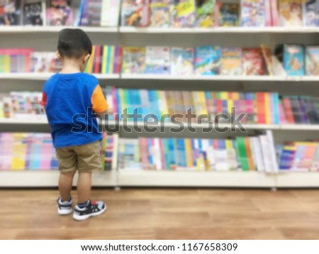Blurred and Defocused Back view of Asian Boy Standing Read a Book at BookStore