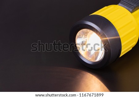 Lit yellow flashlight Royalty-Free Stock Photo #1167671899