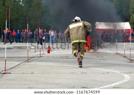 Competitions firefighters. The fireman works with a fire extinguisher to extinguish the fire.
