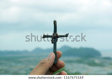 Hand holding a cross. Jesus Christ.        