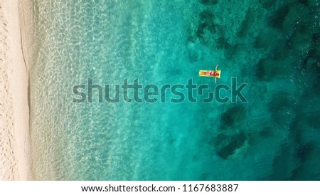 Aerial drone top view photo of tropical paradise deep turquoise beach of Porto Katsiki with people  relaxing in infaltables, Lefkada island, Ionian, Greece