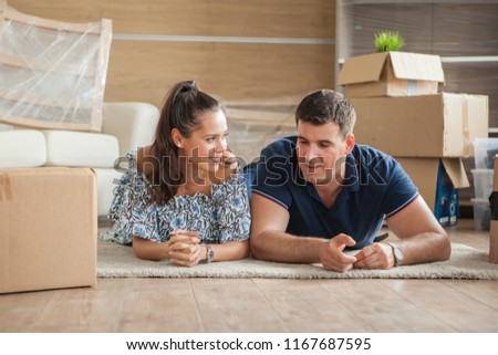 Couple lying happy on the floor on their new house. Mortgage and family