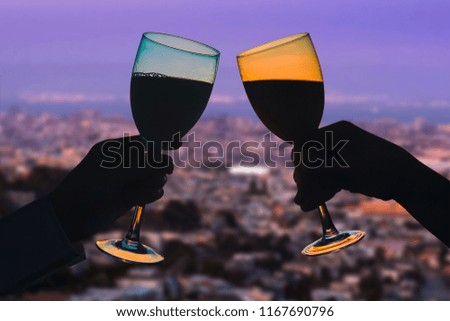 Hands of female's and male's with glass of wine on San Francisco city background. Service on the roof of the restaurant