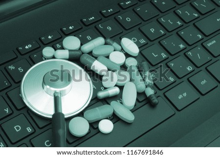 Stethoscope with pills on computer