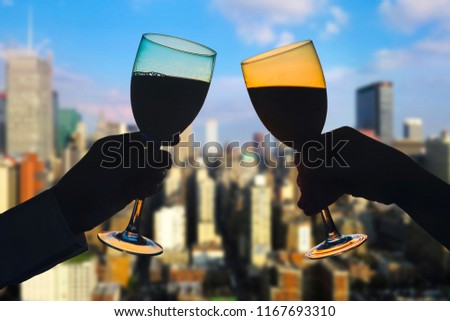  Hands of female's and male's with glass of wine on Manhattan background. New York city.  Service on the roof of the restaurant         
