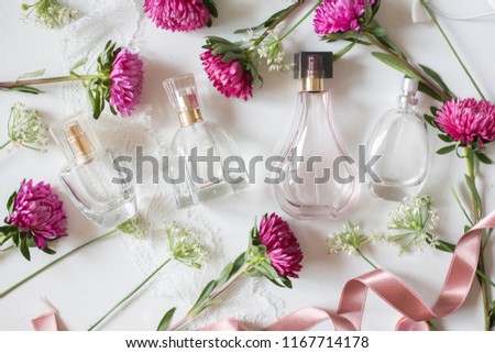 bottle of woman perfume on white background with roses. gift. ribbon asters 