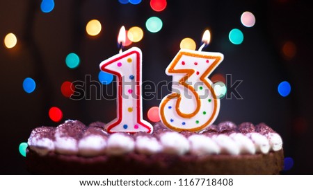 Happy Birthday.Holiday cake with candles.Birthday greetings.Greeting card.Colorful birthday candles.Thirteen years.Growing up.Abstract colorful background.Colorful bokeh.Top view.Stop motion.