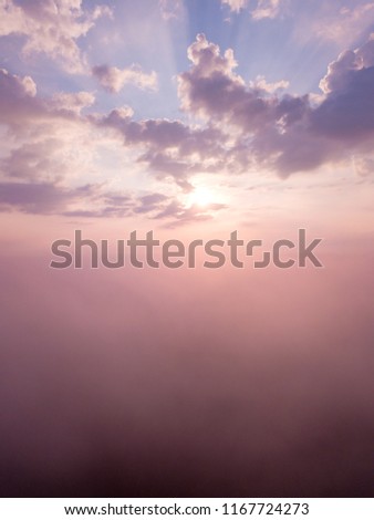 Beautiful foggy sunrise landscape from drone. Magical sunrise over the clouds.