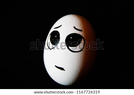 egg on a black background, plaintive, 
emotions on the egg