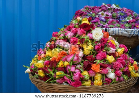 A basket of roses of different colors, for sale at Pune flower market