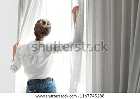 Young happy woman near window at home. Lazy morning