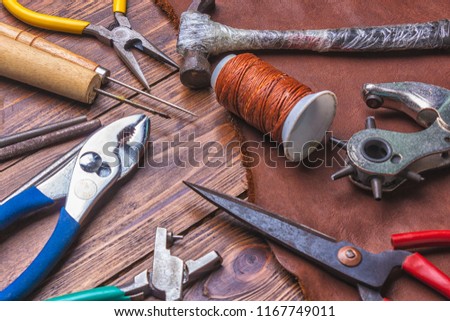 Leather and tools on wooden background