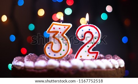 Happy Birthday.Holiday cake with candles.Birthday greetings.Greeting card.Colorful birthday candles.Thirty-two years.Growing up.Abstract colorful background.Colorful bokeh.Top view.Stop motion.
