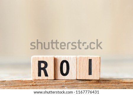 Return on Investment, ROI. Cube wooden block with alphabet building the word ROI.