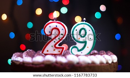 Happy Birthday.Holiday cake with candles.Birthday greetings.Greeting card.Colorful birthday candles.Twenty-nine years.Growing up.Abstract colorful background.Colorful bokeh.Top view.Stop motion.