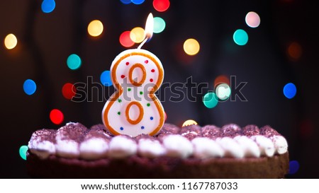 Happy Birthday.Holiday cake with candles.Birthday greetings.Greeting card.Colorful birthday candles.Eight years.Growing up.Abstract colorful background.Colorful bokeh.Top view.Stop motion. Royalty-Free Stock Photo #1167787033