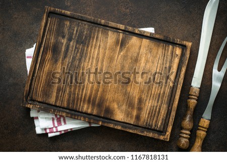 Food cooking background. Fork, knife, cutting board on rusty stone table. Top view.