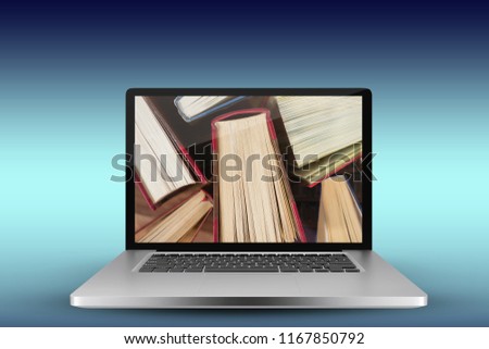 Laptop with with screen against close-up of books arranged