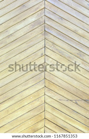 Beautiful background with a texture of thin wooden boards. A wall of pale yellow diagonal slats. An unusual photo.