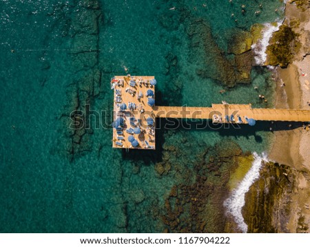 Perspective view of a wooden pier on the seashore, drone view above at the pier with umbrellas by the ocean of Antalya Turkey
