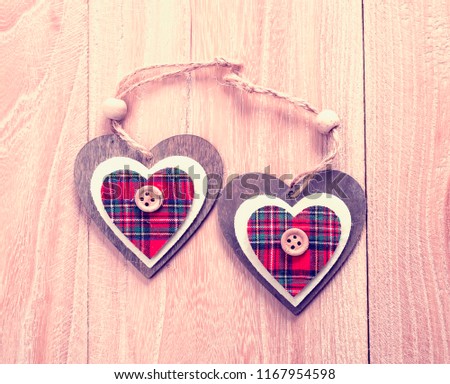 Christmas decoration red, white, gingham, stripes fabric stars and heart shape with buttons on rustic Elm wood background