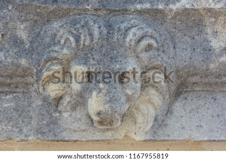 stone slab with carved lion head. ancient art