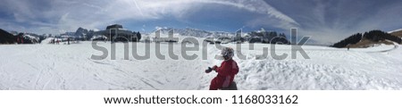 lonely child sitting on a bank in a ski resort