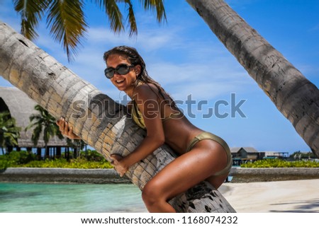girl with a palm tree on the shore of a tropical island

