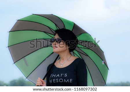 A beautiful woman with green umbrella in the countryside view.