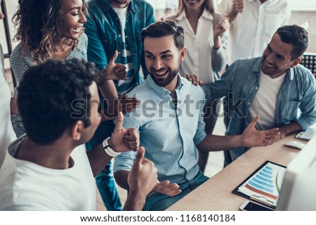 Successful Business Team Congratulating Colleague. Group of Young Happy Collegues Celebrating in Modern Office. Creative Successful Team at Work. Teamwork Concept. Corporate Lifestyle Royalty-Free Stock Photo #1168140184