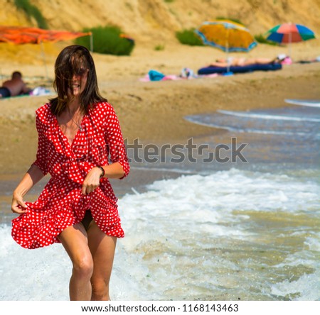 Young girl running through the sea beach at sunny day.