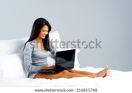 woman using laptop in bed at home, leisure lifestyle concept