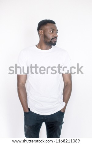 Positive human emotions, facial expressions, feelings, attitude and reaction. Friendly-looking young African American man dressed in white t-shirt and jeans posing in studio on white background