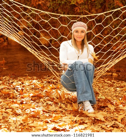 Photo of pretty girl swinging in hammock in garden, cute young lady having fun outdoors