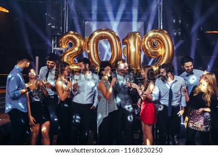 Group of friends celebrating New Year with champagne Royalty-Free Stock Photo #1168230250