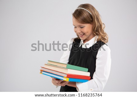 Expressive portrait of a smiling beautiful young schoolgirl with school textbooks.Portrait of a girl on an isolated background