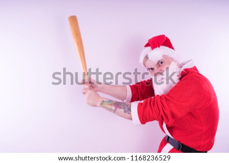 Emotional Santa Claus with a tattoo and a baseball bat on white background. The concept of an evil Santa Claus. Happy New Year and merry Christmas!    