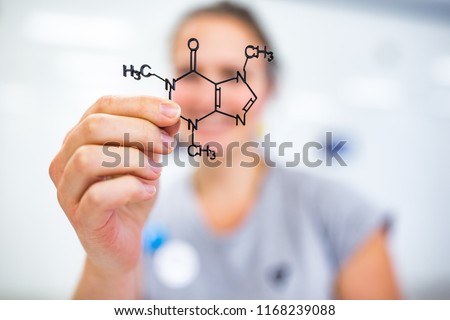 Young woman holding up a molecular model of nicotin