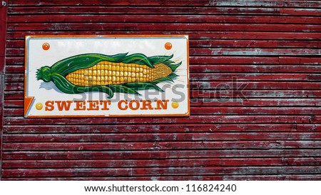 Rural Sweet Corn sign on the side of a farmer's red barn