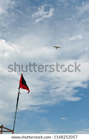 flag of dangerous waters on beach with plane flying over
