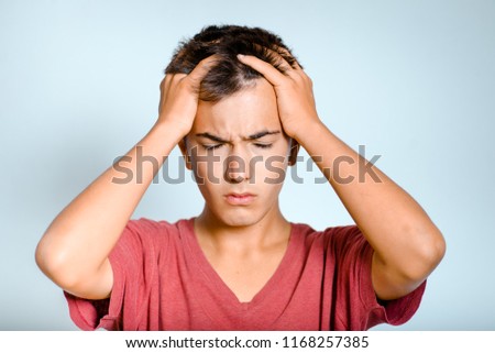 young man has a headache, migraines, isolated studio photo on the background