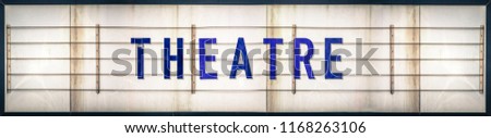 A Grungy Old Weathered Theatre Marquee Sign With Blue Letters