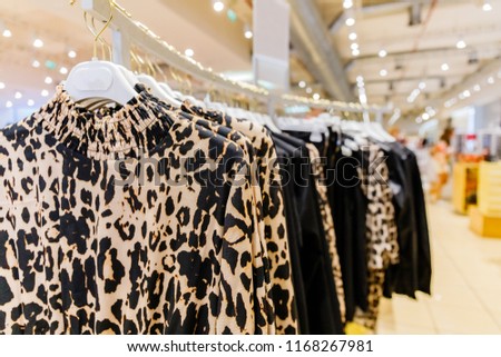 Women's blouses with classic animal print hang on hangers