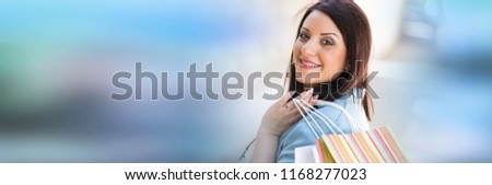 Pretty young woman walking with shopping bags in hand